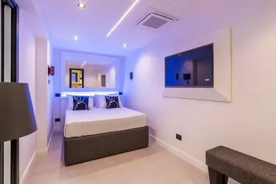 a bedroom with a bed and a tv on the wall at JOIVY Borghese Luxury Suite in Rome