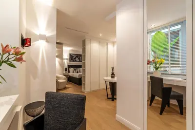 a living room with a table and chairs and a bedroom at JOIVY Borghese Luxury Suite in Rome