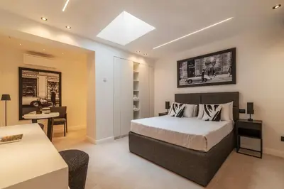 a bedroom with a bed and a room with a table at JOIVY Borghese Luxury Suite in Rome