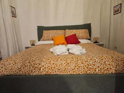 a bed with a pile of towels on it at Raggio di Sole in Rome