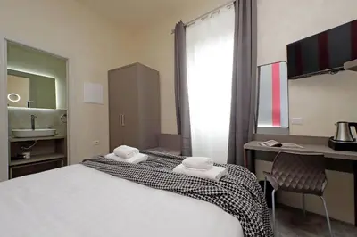 a bedroom with a bed and a desk and a sink at Termini Comfort Rooms and Jacuzzi Suite by Flatinrome in Rome