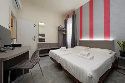 a hotel room with a large bed and a desk at Termini Comfort Rooms and Jacuzzi Suite by Flatinrome in Rome