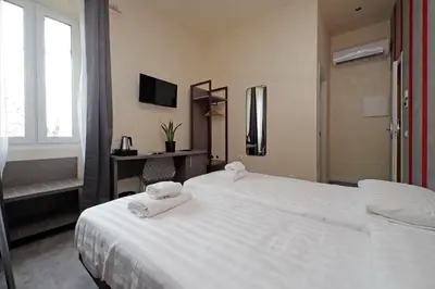 a hotel room with two beds and a desk at Termini Comfort Rooms and Jacuzzi Suite by Flatinrome in Rome