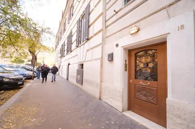 people walking down a sidewalk next to a building with a door at Ad un passo da San Pietro in Rome