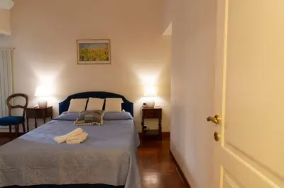a bedroom with a blue bed with two lights on at Sistina 138 Luxury Home in Rome