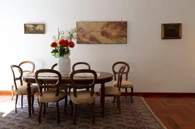 a table with chairs and a vase with flowers on it at Sistina 138 Luxury Home in Rome