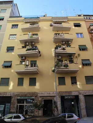 a tall yellow building with balconies on it at Sara's Home - Modern Apartment Near Metro, Perfect for Families and Groups in Rome in Rome