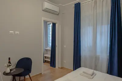 a bedroom with a bed and a table and a window at GoldStar apartments in Rome