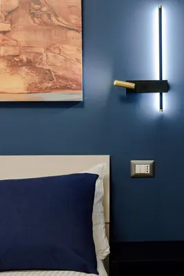 a bedroom with a blue wall with a bed and a thermometer at GoldStar apartments in Rome