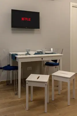 a white table with two chairs and a tv on the wall at GoldStar apartments in Rome