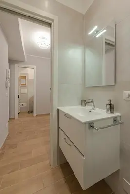 a white bathroom with a sink and a mirror at GoldStar apartments in Rome