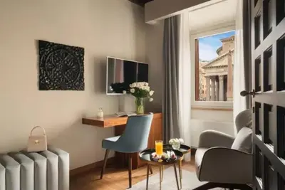a room with a desk and chairs and a window at pantheon suite 11 in Rome