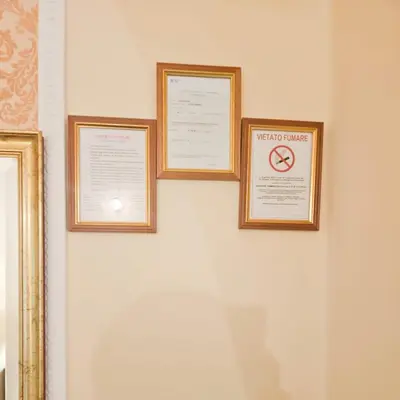 three framed pictures on a wall with a no smoking sign at Hotel Giubileo in Rome