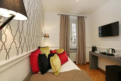 a hotel room with a bed with red and yellow pillows at Domus Leonina - Stunning Terrace on the Roman Forum in Rome