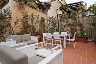 a patio with a table and chairs and plants at Domus Leonina - Stunning Terrace on the Roman Forum in Rome