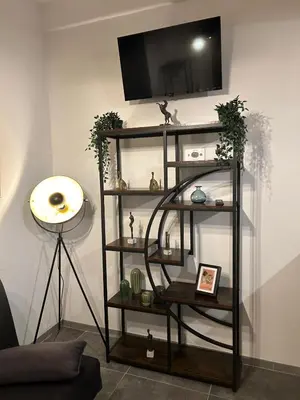 a black shelf with a tv on a wall at San Giovanni Studio in Rome