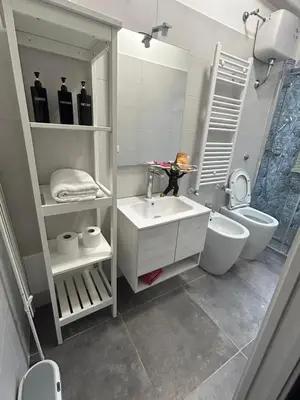 a white bathroom with a sink and a toilet at San Giovanni Studio in Rome