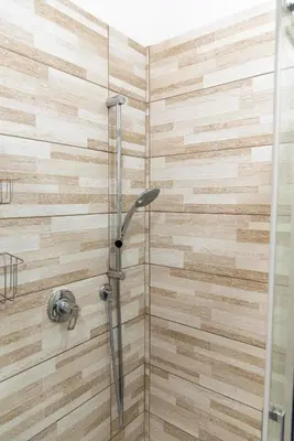 a bathroom with a shower with a glass door at Sidama Boutique Stay in Rome