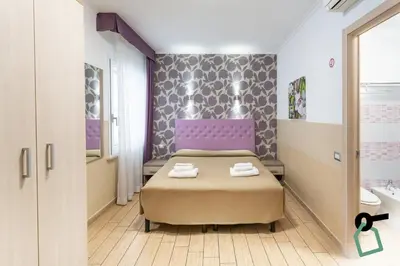 a bedroom with a bed with two towels on it at HOTIDAY Room Collection - Roma Barberini in Rome