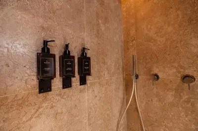 a bathroom with two lights on the wall of a shower at Whim Collection Trastevere in Rome