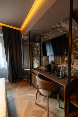 a room with a desk with a television on a wall at Whim Collection Trastevere in Rome