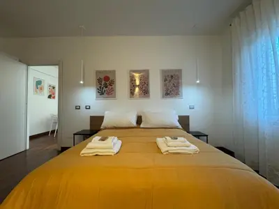 a bedroom with a large yellow bed with towels on it at Papa's Apartment - A new flat in Portuense in Rome