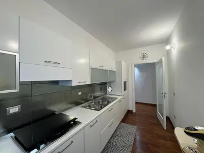 a kitchen with white cabinets and a counter top at Papa's Apartment - A new flat in Portuense in Rome