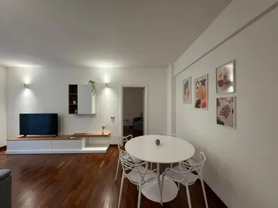 a living room with a table and chairs and a tv at Papa's Apartment - A new flat in Portuense in Rome