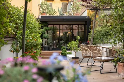 a patio with chairs and flowers in front of a building at Terrazza segreta del Vaticano in Rome