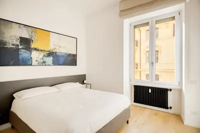 a white bedroom with a bed and a window at Appartamento Roma Sallustiano in Rome