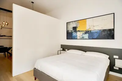 a bedroom with a white bed and a painting on the wall at Appartamento Roma Sallustiano in Rome