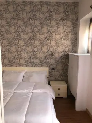 a bedroom with a white bed with a wall at Mattia Home in Rome