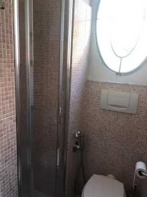 a bathroom with a shower with a toilet and a window at Mattia Home in Rome