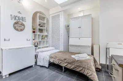 a white room with a bed and a refrigerator at Battistini Sweet House in Rome