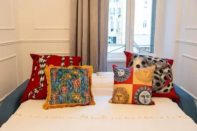 a bed with colorful pillows on it at Vatican Boutique RHome in Rome