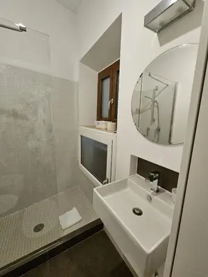a white bathroom with a sink and a shower at Be Your Home - Casa di Arya in Rome
