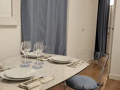 a table with plates and wine glasses on it at Be Your Home - Casa di Arya in Rome