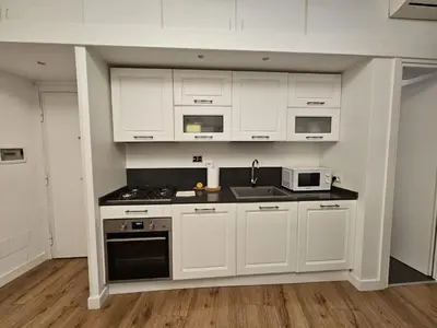 a kitchen with white cabinets and a stove top oven at Be Your Home - Casa di Arya in Rome