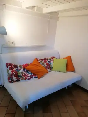 a white couch with colorful pillows on it at All'angolo di San Pietro - wifi in Rome