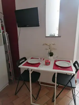 a white table with two chairs and a tv on the wall at All'angolo di San Pietro - wifi in Rome