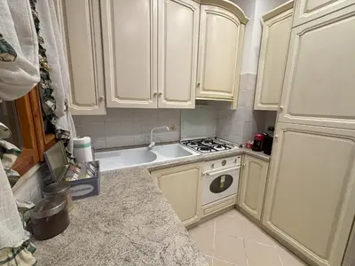 a small kitchen with white cabinets and a stove at Ai Quattro Cantoni in Rome