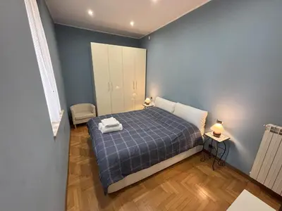 a bedroom with a bed with blue walls and wooden floors at Ai Quattro Cantoni in Rome
