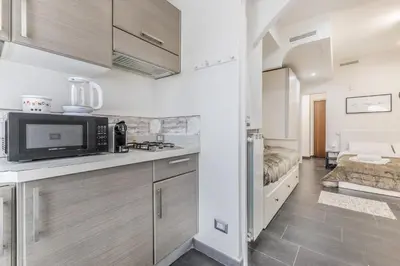 a kitchen with a microwave oven and a stove at Battistini Sweet Apartament in Rome