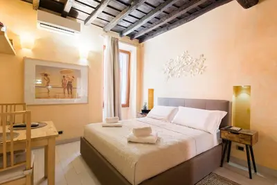 a bedroom with a bed and a table and a window at Trinità Dei Monti in Rome