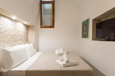 a bedroom with a bed with towels and a tv at Trinità Dei Monti in Rome