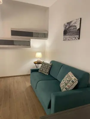 a living room with a green couch and a lamp at Pineta Domus in Rome