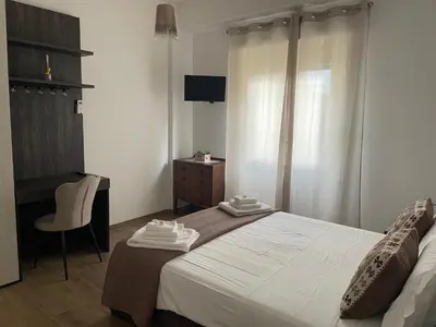 a bedroom with a bed and a desk and a chair at Pineta Domus in Rome