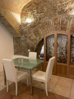 a dining room with a glass table and white chairs at Roman times experience in Monti area in Rome