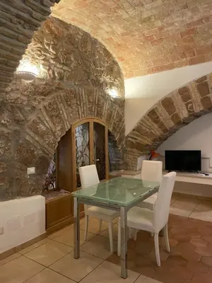 a dining room with a glass table and white chairs at Roman times experience in Monti area in Rome