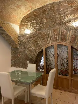 a dining room with a table and chairs and a stone ceiling at Roman times experience in Monti area in Rome